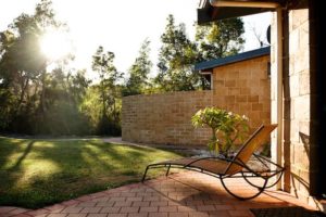 Leela outside with grass, handmade bricks and a lounger