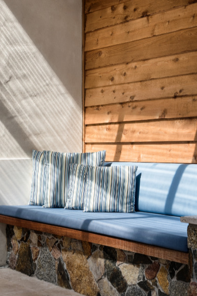 Outdoor seat in dappled sunlight.
