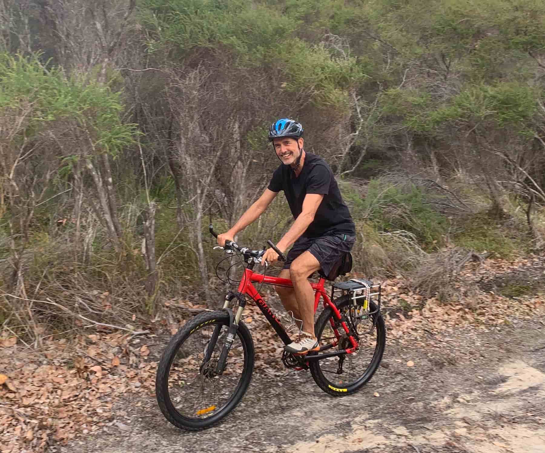 Gadi cycling on a bike in the bush